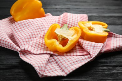 Kitchen towel and bell peppers on black wooden table