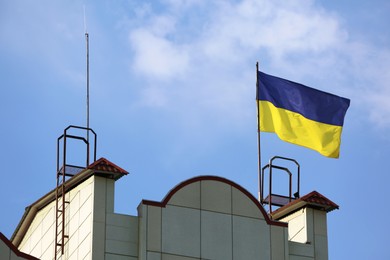 Ukrainian flag on building against blue sky