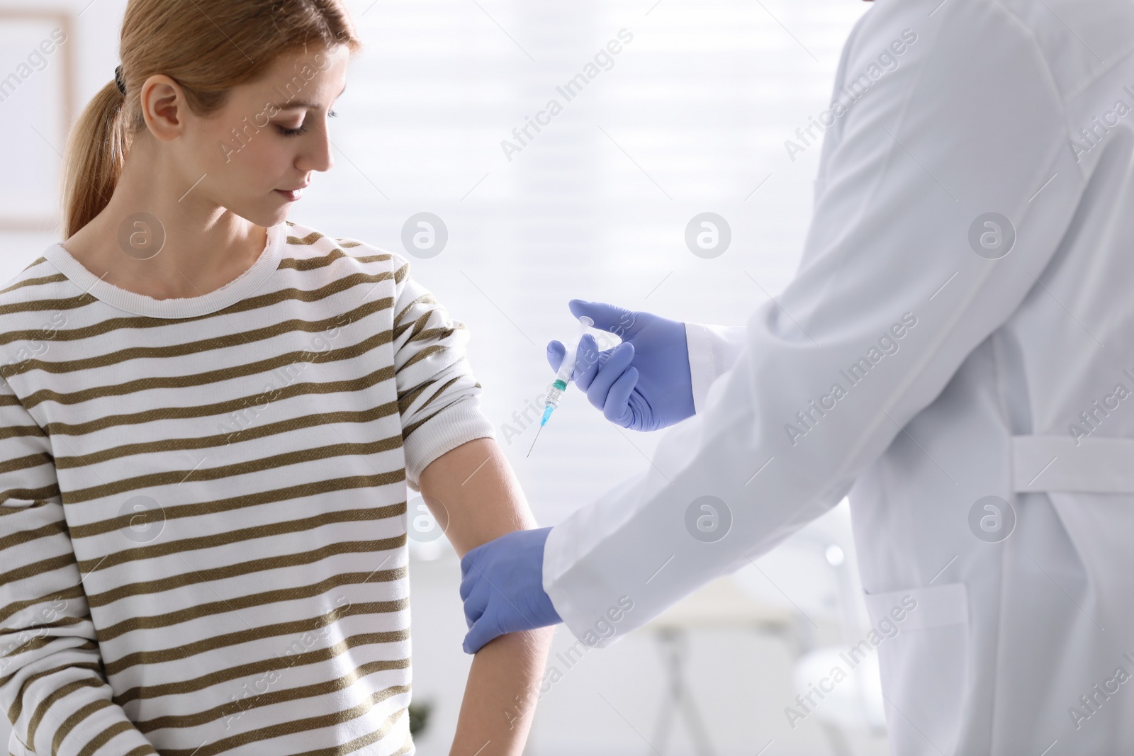 Photo of Doctor giving injection to patient in hospital. Vaccination concept