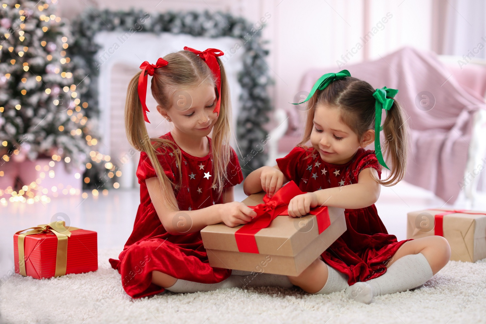 Photo of Cute little children with Christmas gifts at home