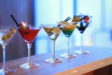 Photo of Different martini cocktails on table in bar, space for text