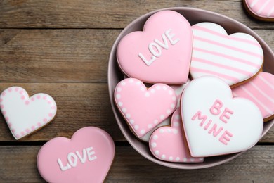 Decorated heart shaped cookies on wooden table, flat lay. Valentine's day treat