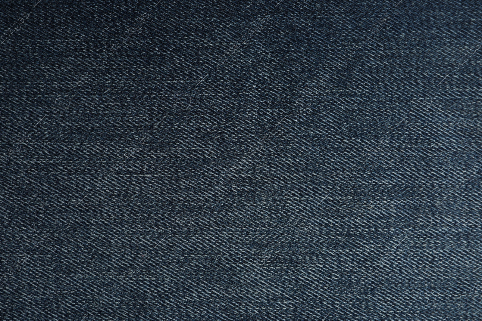 Photo of Texture of dark blue jeans as background, closeup