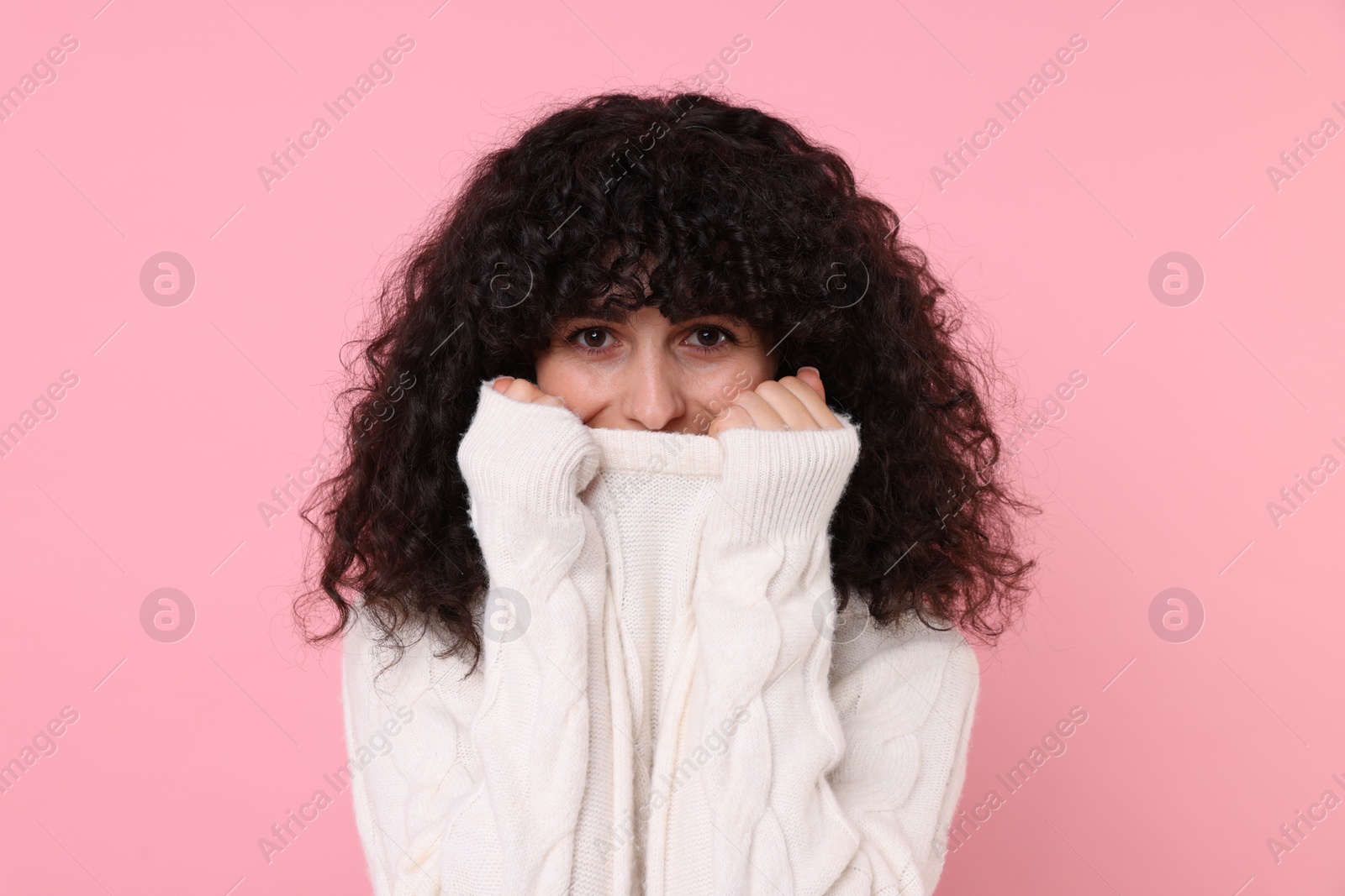 Photo of Young woman in stylish white sweater on pink background