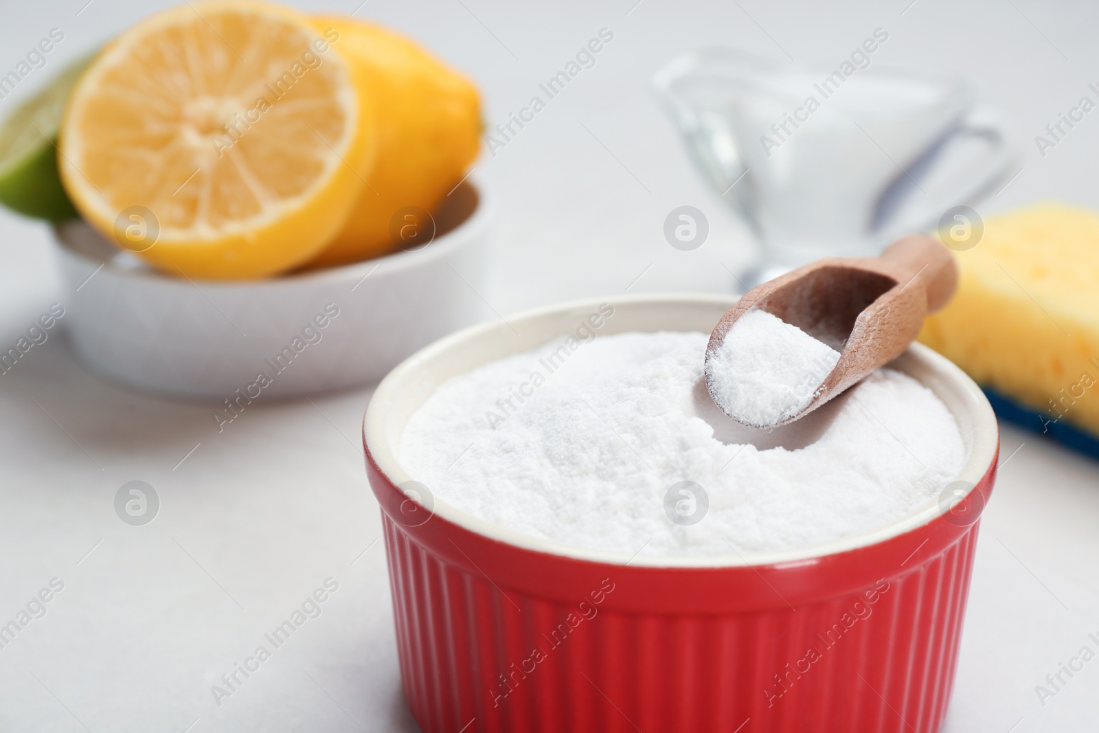 Photo of Bowl and scoop with baking soda on gray table