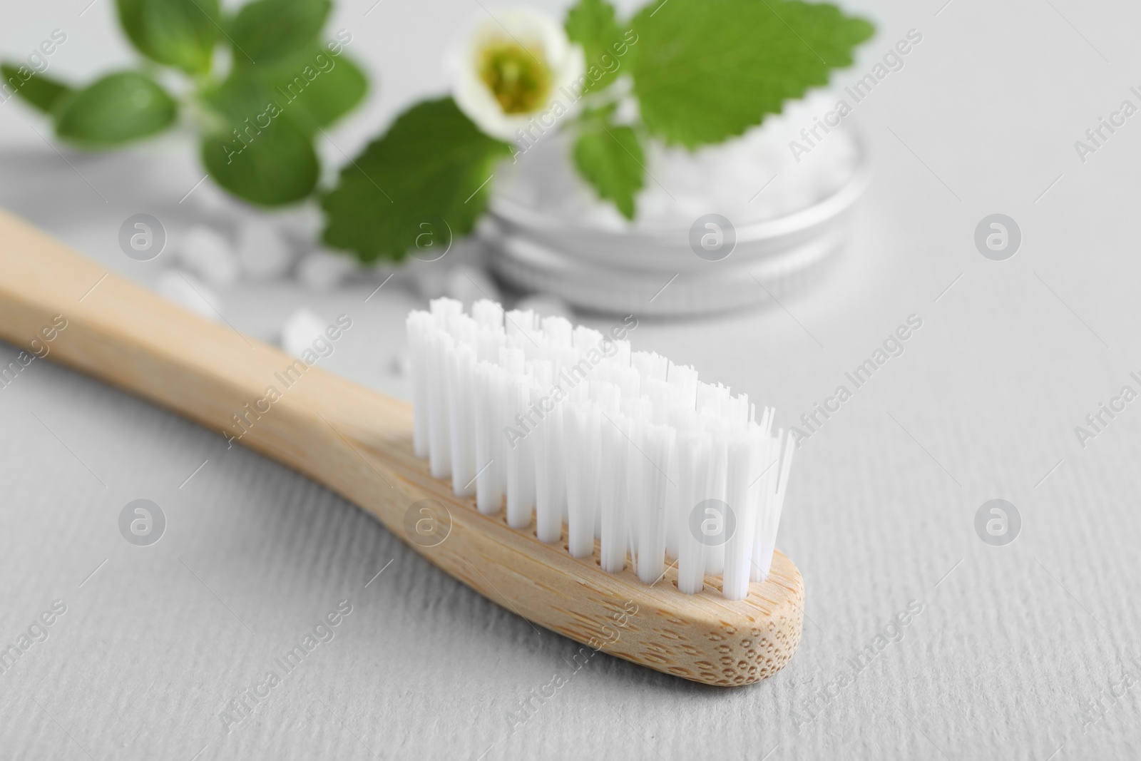 Photo of Toothbrush, salt and herbs on white background, closeup