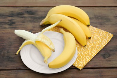 Many delicious ripe bananas on wooden table