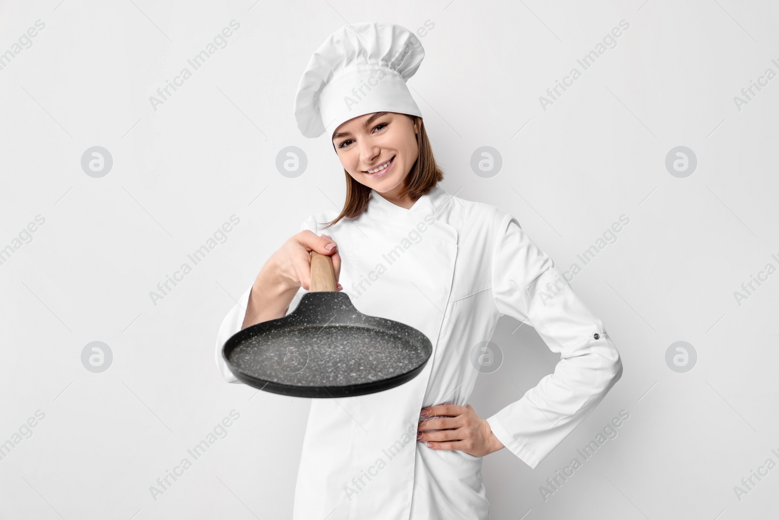 Photo of Professional chef with frying pan on light background