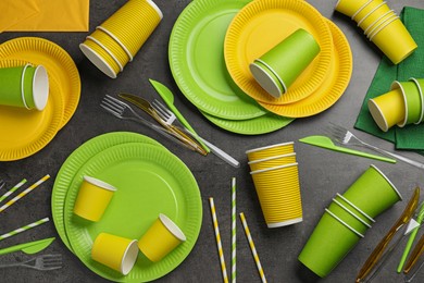 Photo of Flat lay composition with disposable tableware on dark grey background