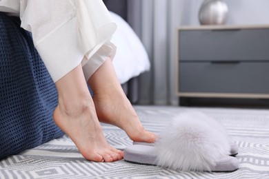Photo of Woman near grey soft slippers at home, closeup
