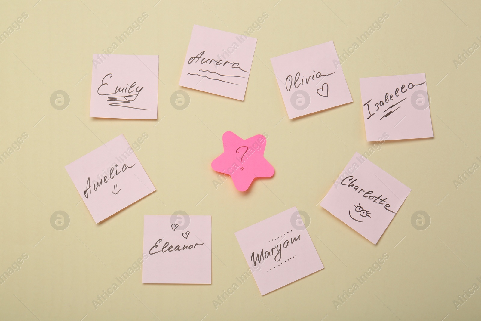 Photo of Choosing baby name. Paper stickers with different names and question mark on beige background, flat lay