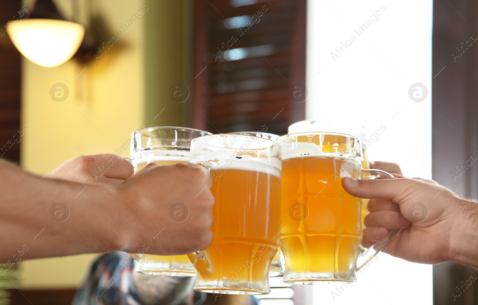 Photo of Friends clinking glasses with beer in pub