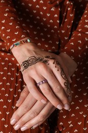 Photo of Woman with henna tattoo on hand, closeup. Traditional mehndi ornament