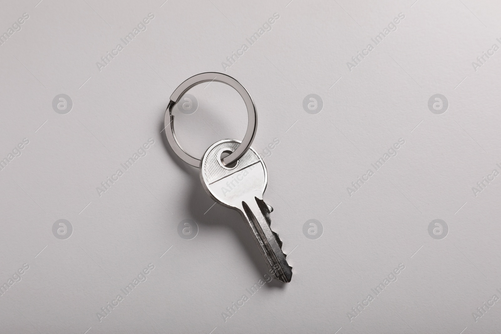 Photo of House key on light grey background, top view. Real estate agent services