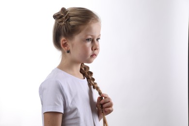 Little girl with braided hair on white background. Space for text