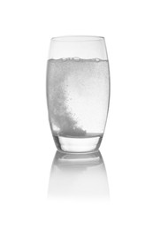 Effervescent pill dissolving in glass of water isolated on white