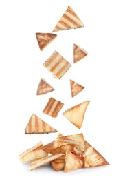 Image of Delicious crispy pita chips falling into heap on white background