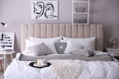 Cozy bedroom interior with cushions and striped blanket
