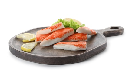 Serving plate with cut crab sticks on white background