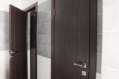 Photo of Two brown wooden doors in public toilet