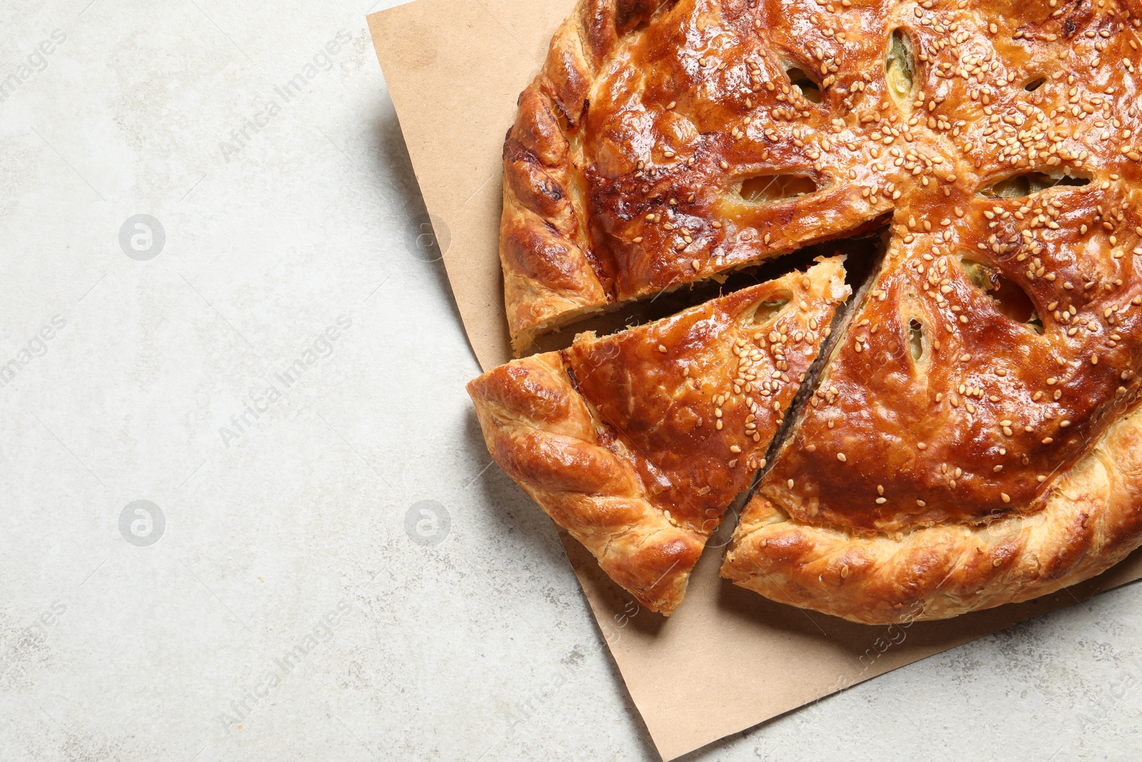 Photo of Cut delicious homemade pie on light grey table, top view. Space for text