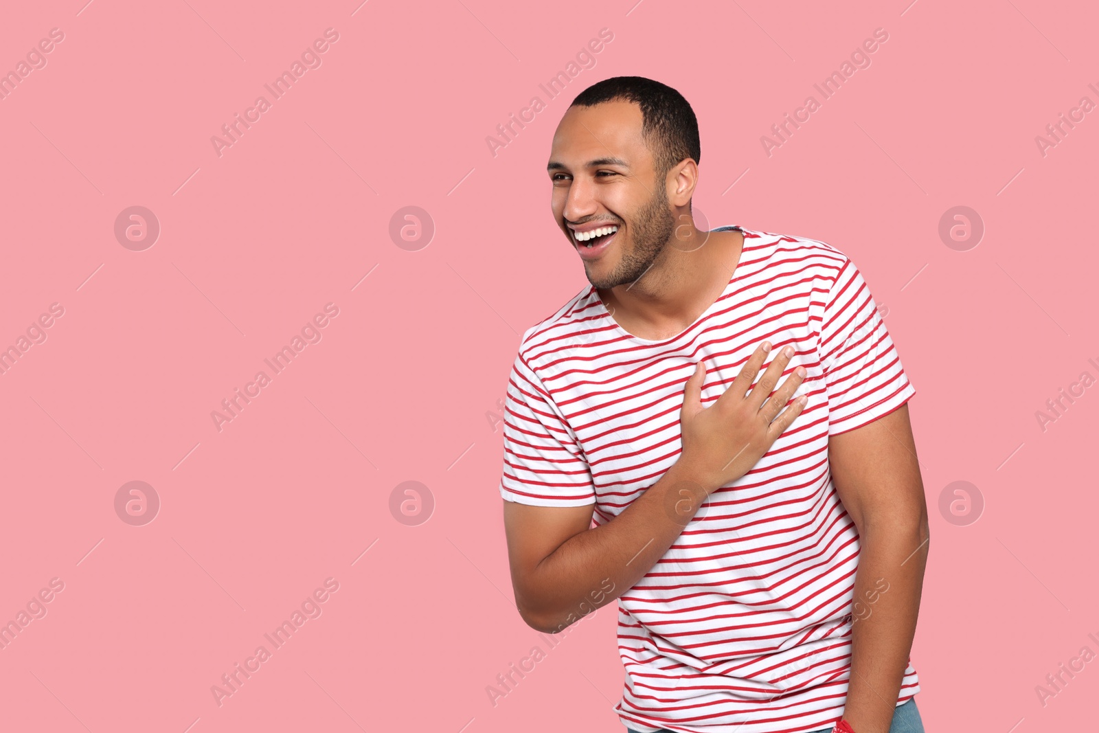 Photo of Portrait of laughing African American man on pink background. Space for text