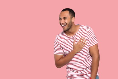Photo of Portrait of laughing African American man on pink background. Space for text