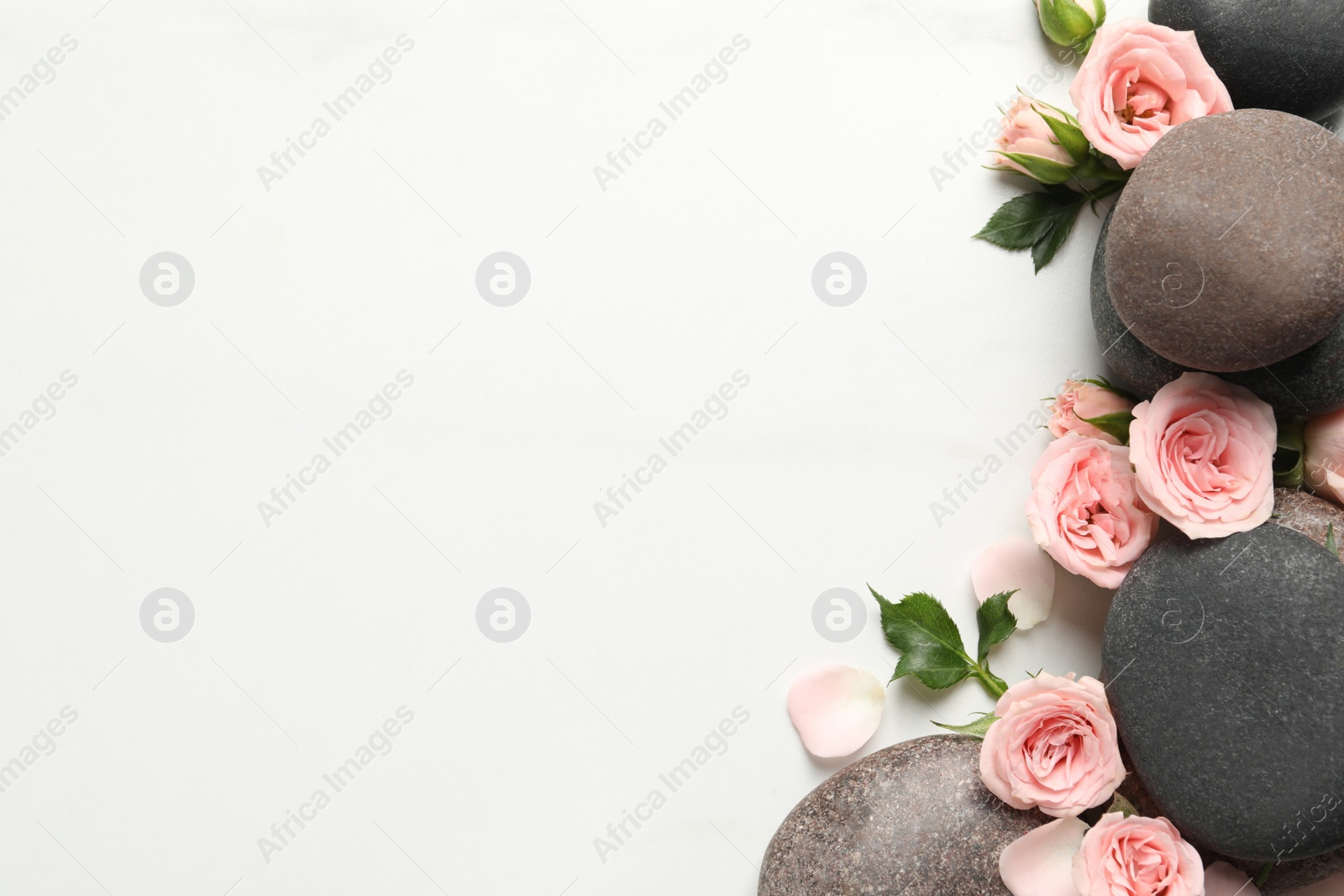 Photo of Flat lay composition with spa stones and roses on white marble table. Space for text