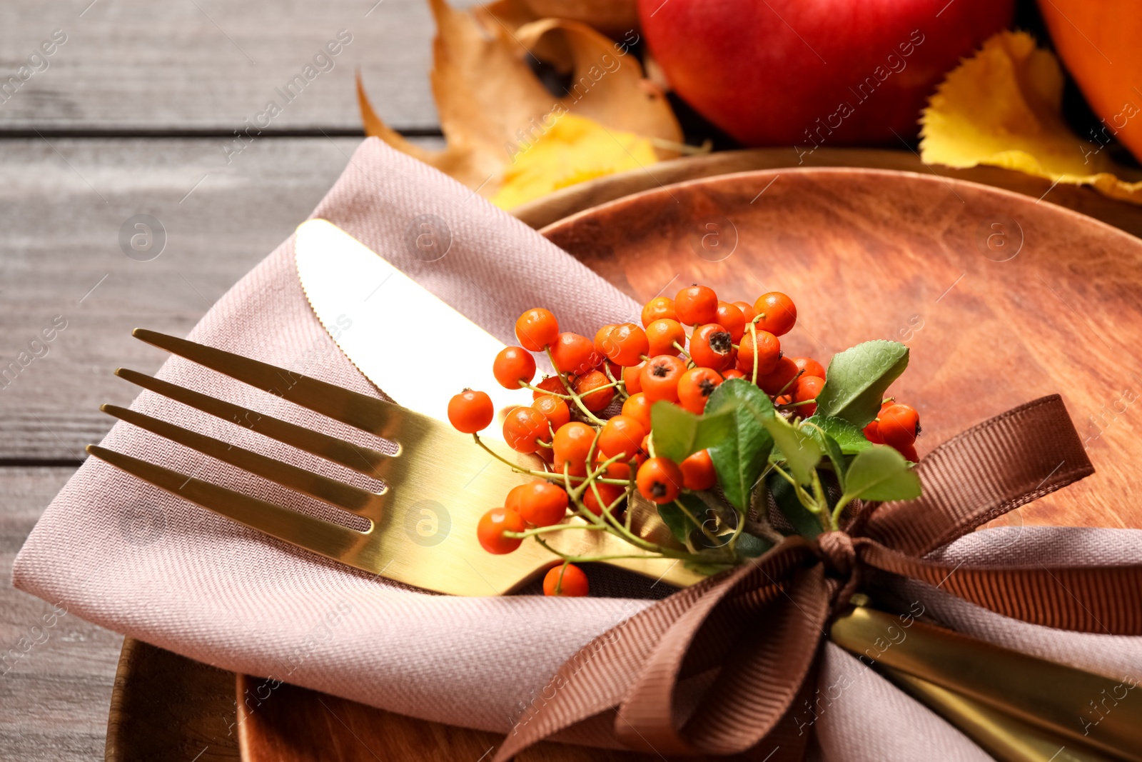 Photo of Table setting with rowan berries on wooden background, closeup. Thanksgiving Day