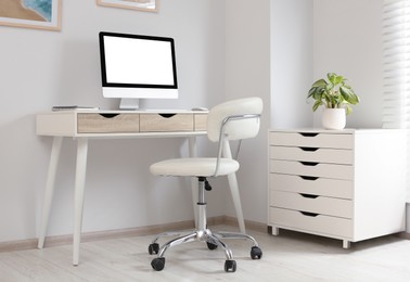 Photo of Stylish office interior with comfortable chair, desk and computer