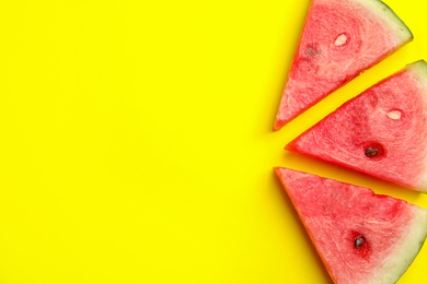 Slices of ripe watermelon on yellow background, flat lay. Space for text