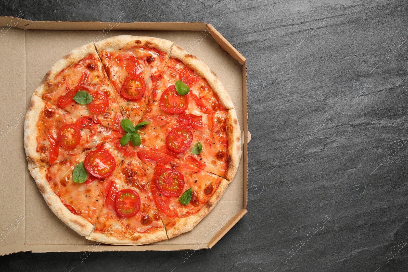 Photo of Delicious pizza Margherita on dark grey table, top view. Space for text