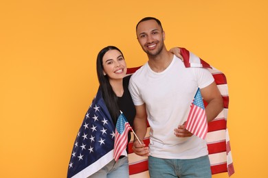 Photo of 4th of July - Independence Day of USA. Happy couple with American flags on yellow background, space for text