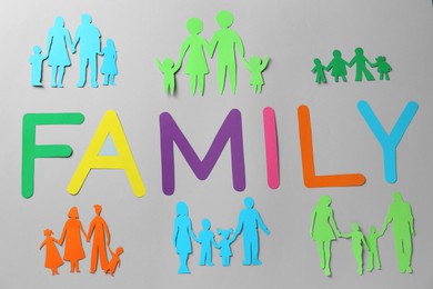 Photo of Paper cutouts and word Family made of colorful letters on grey background, flat lay