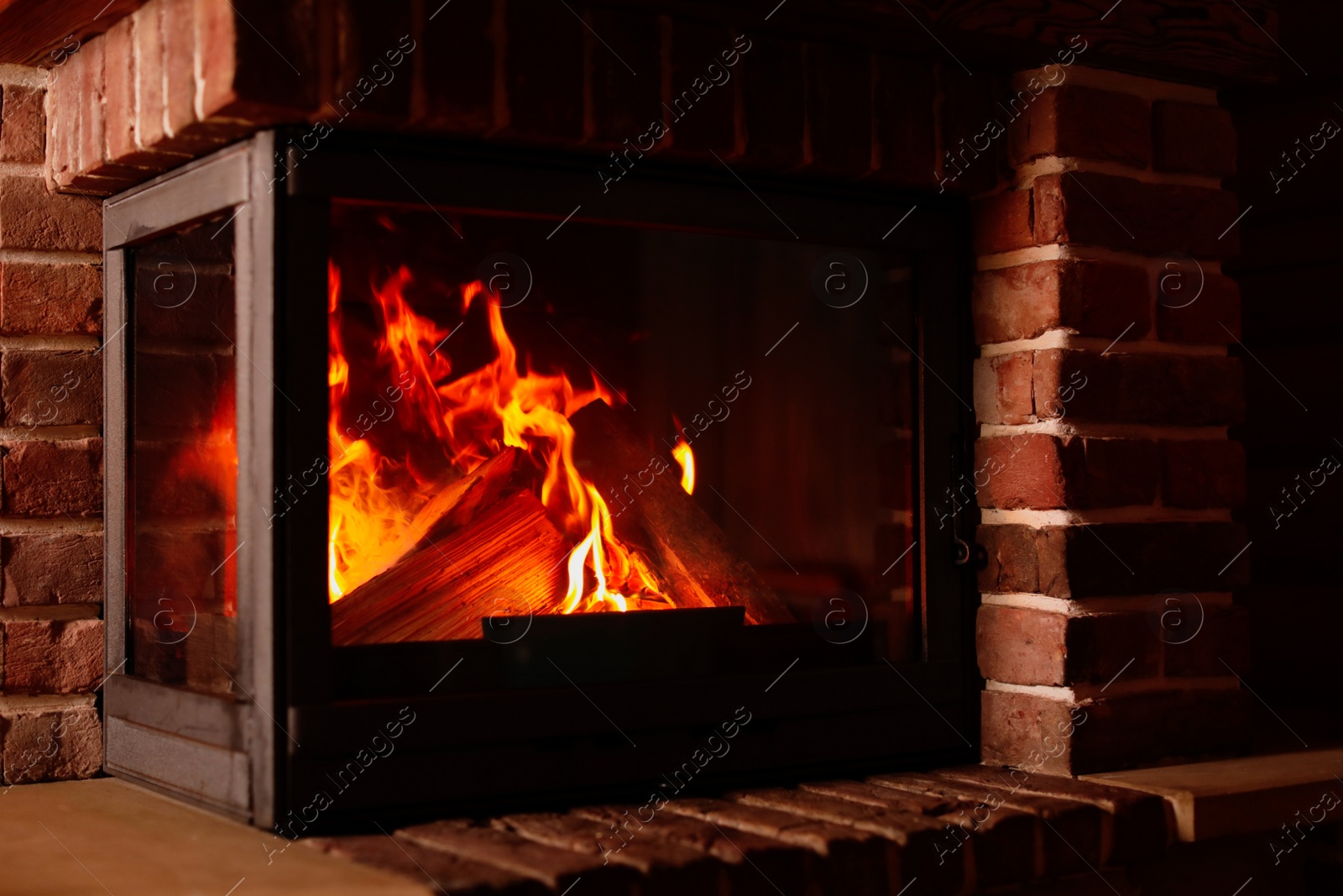 Photo of Fireplace with burning wood indoors. Winter vacation