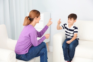 Hearing impaired mother and her child talking with help of sign language indoors