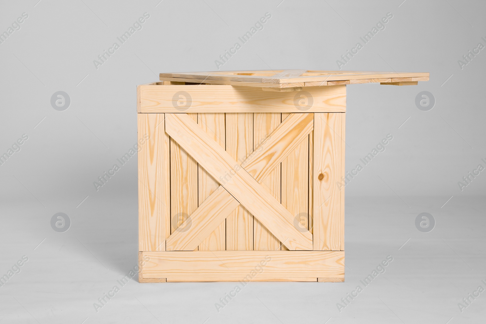 Photo of One open wooden crate on grey background