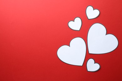 Paper hearts on red background, flat lay. Space for text