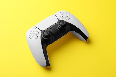 Photo of One wireless game controller on yellow background