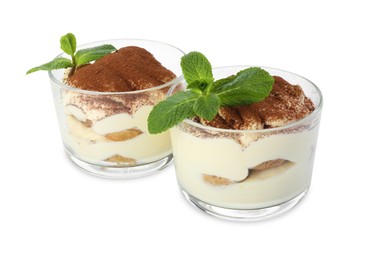 Photo of Delicious tiramisu with mint in glasses isolated on white