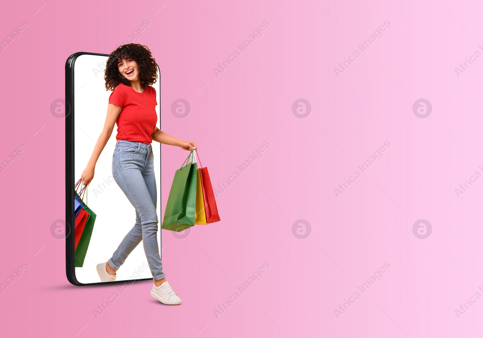 Image of Online shopping. Happy woman with paper bags walking out from smartphone on pink background, space for text