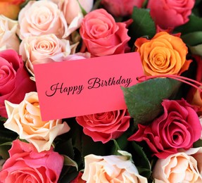 Image of Bouquet of beautiful roses with Happy Birthday card, closeup