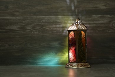 Photo of Decorative Arabic lantern on grey table. Space for text