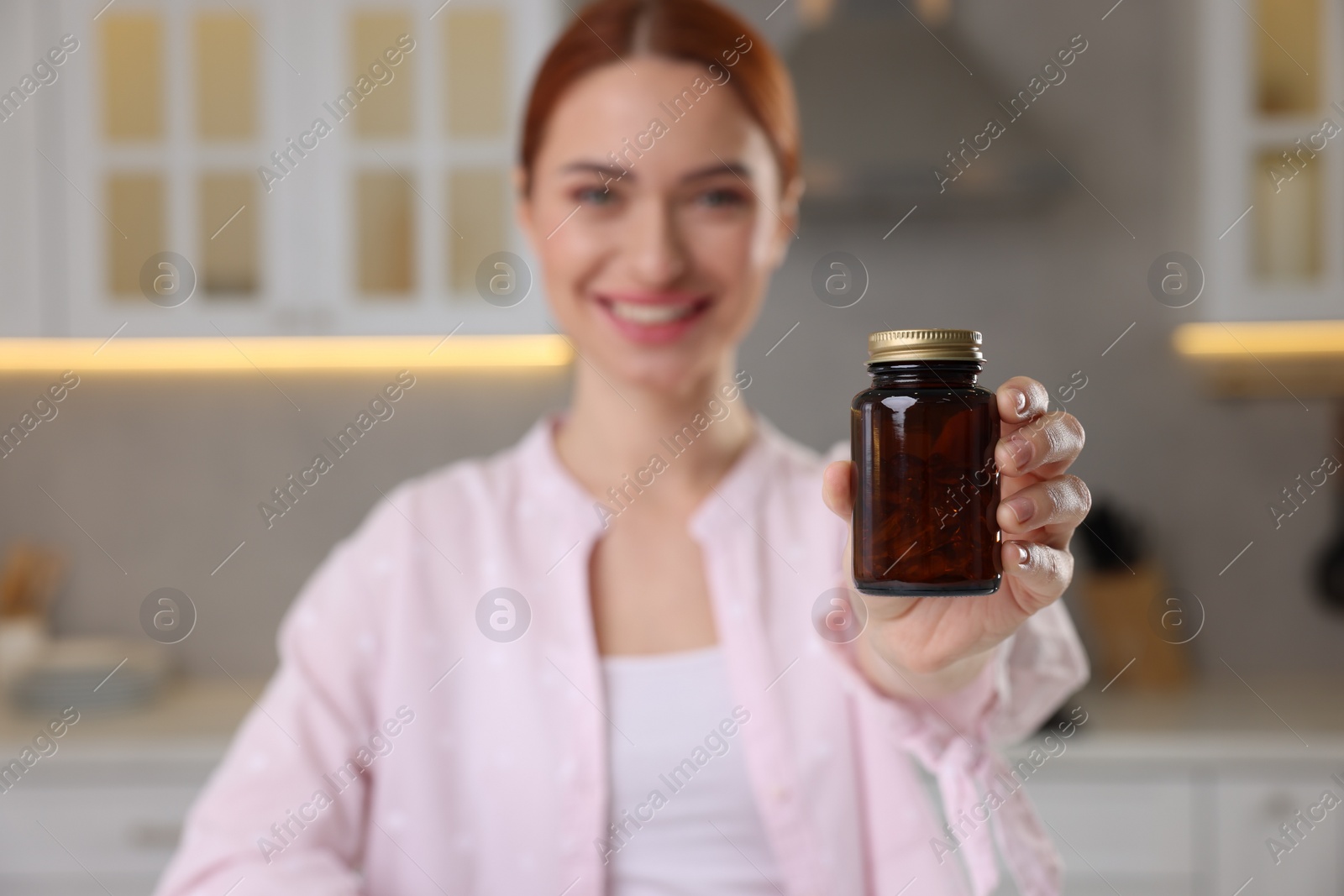 Photo of Beautiful young woman with jar of vitamin pills at home, selective focus