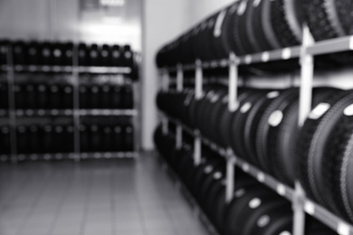 Blurred view of car tires on rack in auto store