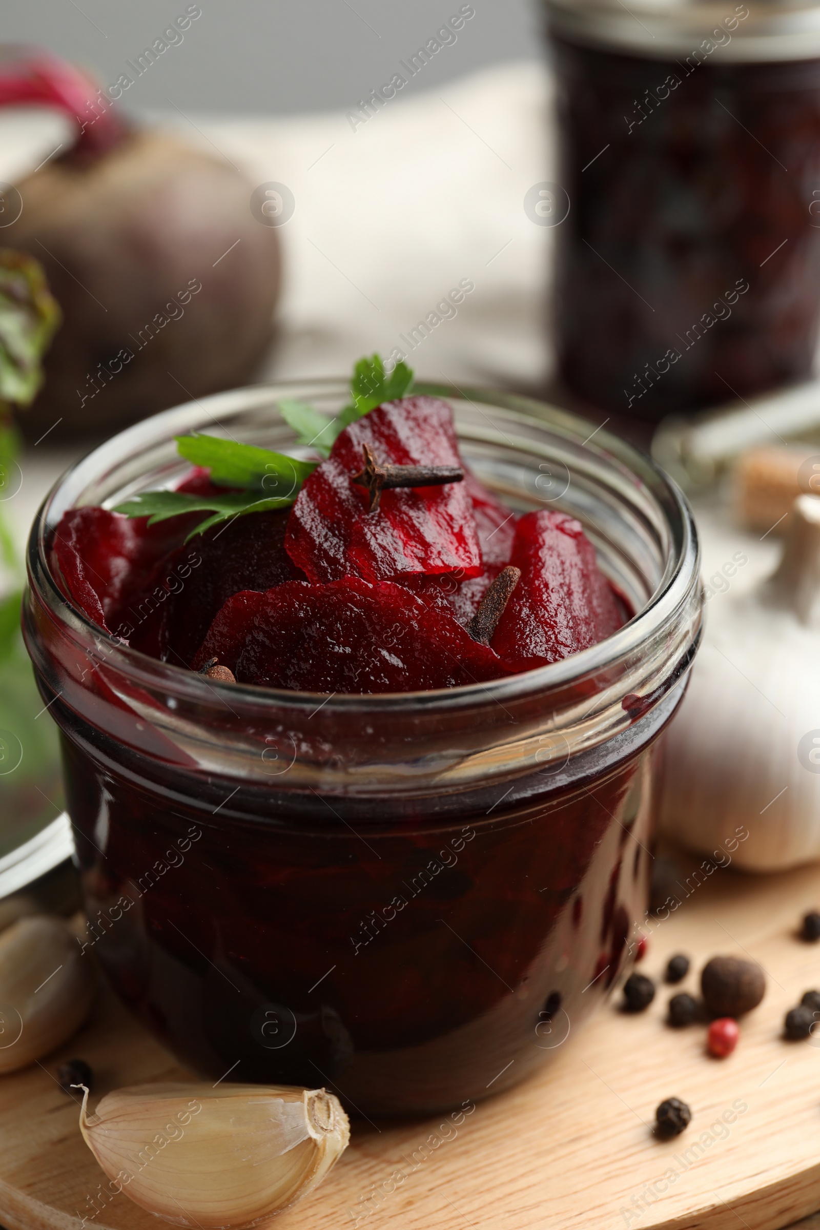 Photo of Delicious pickled beets and spices on wooden board