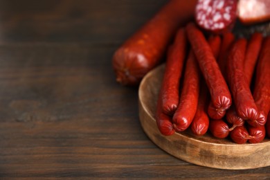 Photo of Different types of sausages on wooden table, space for text