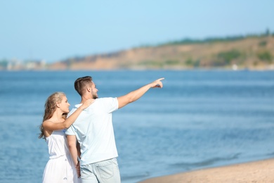 Happy young couple at beach on sunny day