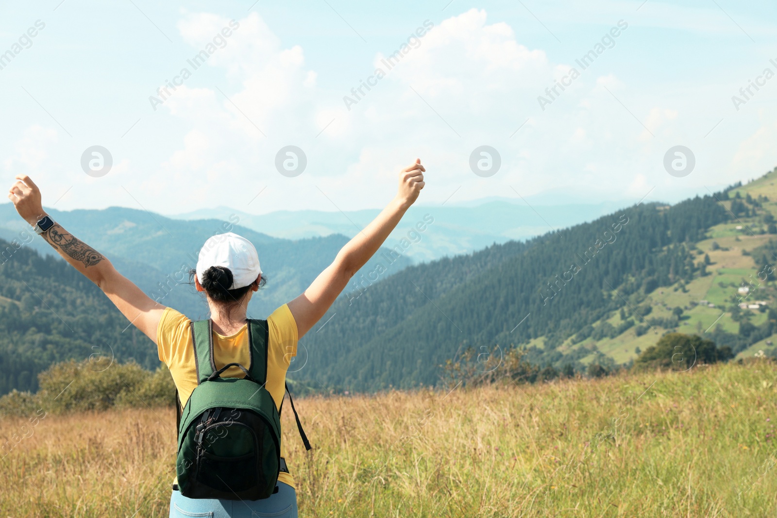 Photo of Woman with backpack in wilderness. Mountain landscape