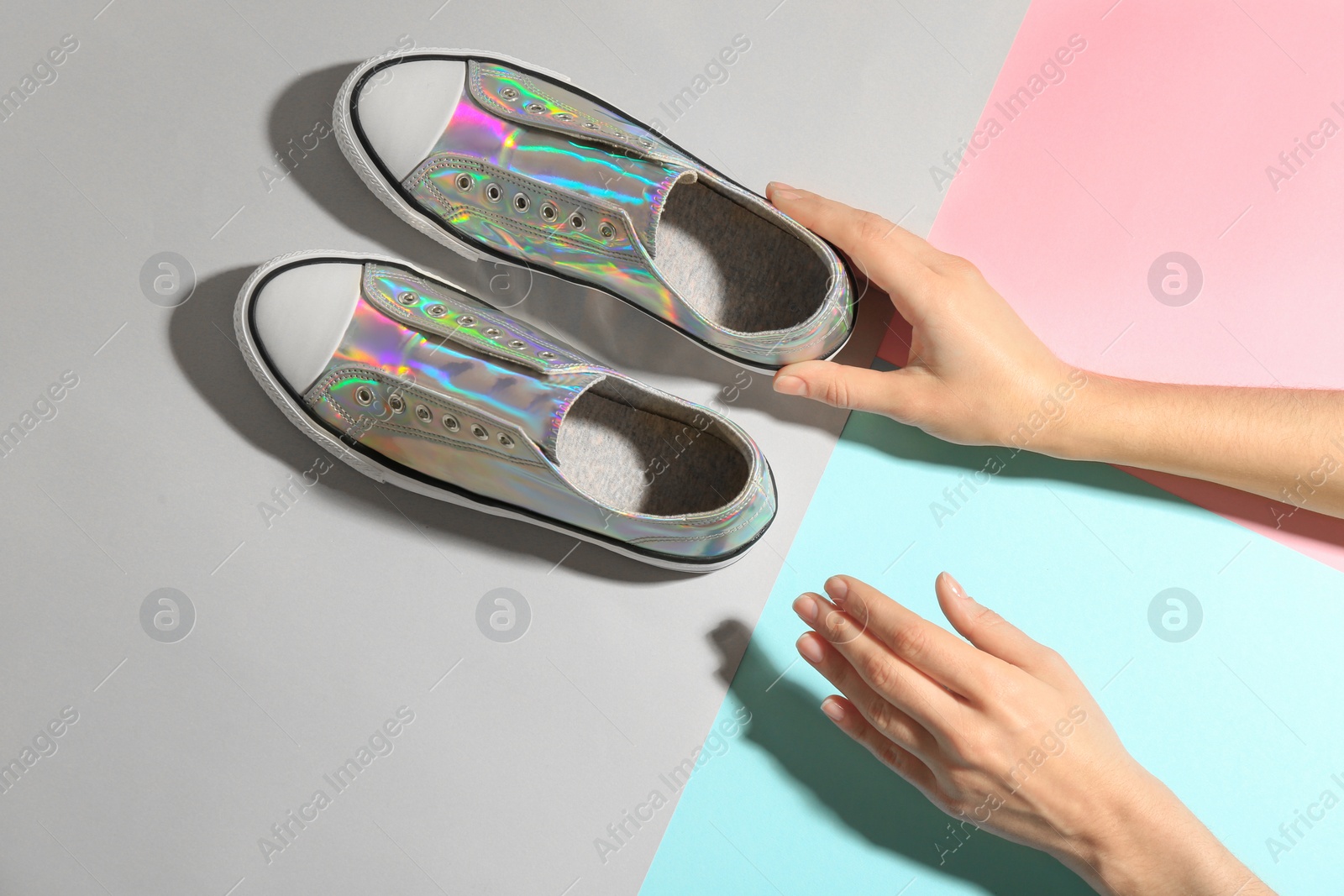 Photo of Woman with stylish sneakers on color background, top view